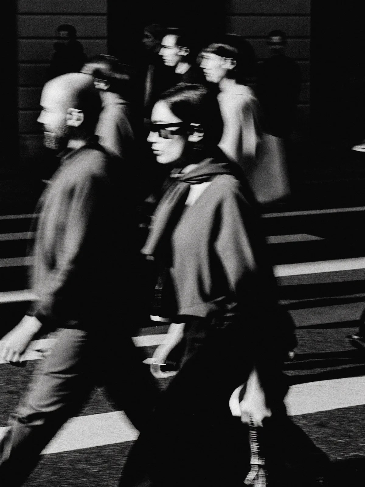 Foule urbaine en flou de mouvement, une silhouette nette au centre, noir et blanc